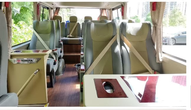 Toyota Coaster interior with leather recliner seats and wooden floor