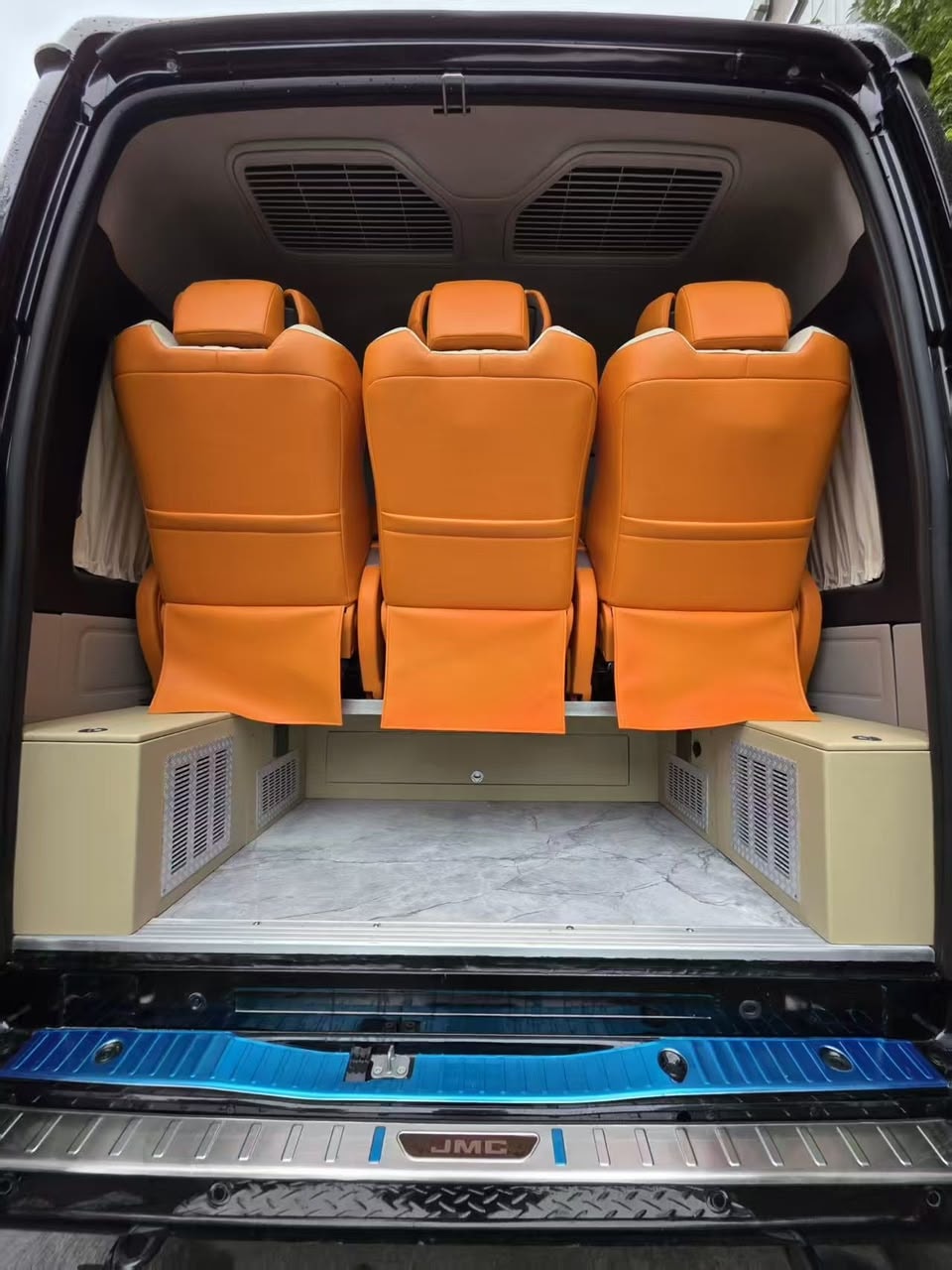 JMC van rear seating area with orange leather captain seats